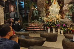 Sebuah keluarga berdoa didepan Gua Maria